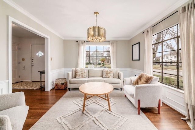 living room with ornamental molding, dark hardwood / wood-style floors, and a notable chandelier