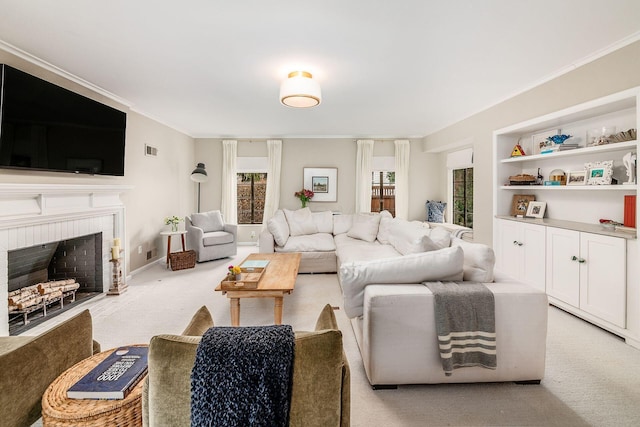 living room with crown molding, a brick fireplace, and light carpet