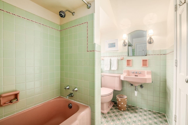 full bathroom featuring sink, tile walls, tile patterned flooring, tiled shower / bath, and toilet