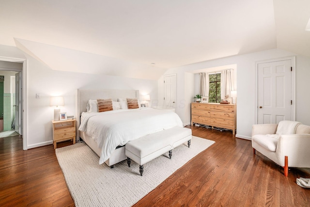 bedroom with lofted ceiling and dark hardwood / wood-style floors