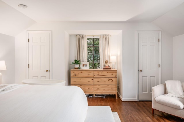 bedroom with lofted ceiling and dark hardwood / wood-style floors