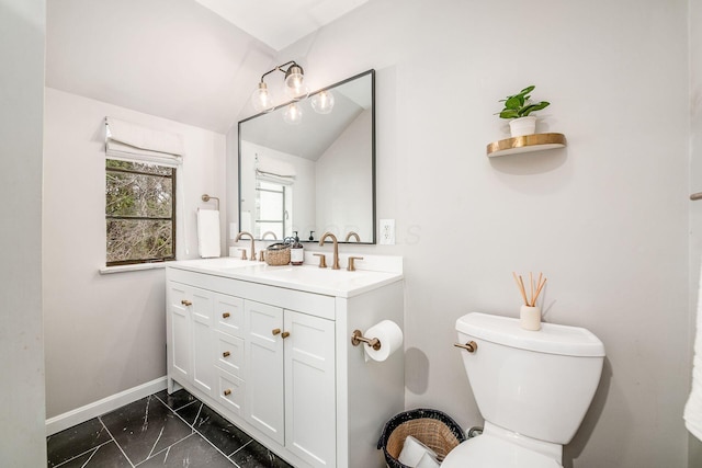 bathroom featuring lofted ceiling, vanity, and toilet