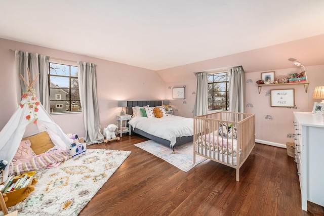 bedroom featuring lofted ceiling, dark hardwood / wood-style flooring, and multiple windows