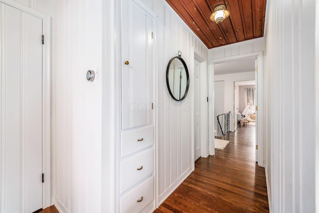 hallway with dark wood-type flooring and wood ceiling