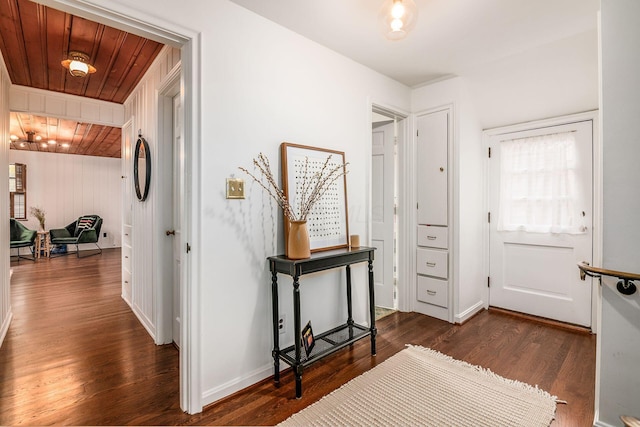 hall featuring dark wood-type flooring and wood ceiling