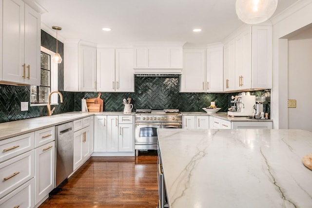 kitchen with light stone countertops, white cabinetry, appliances with stainless steel finishes, and decorative light fixtures