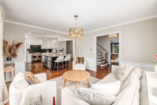 living room featuring dark wood-type flooring, crown molding, and a notable chandelier