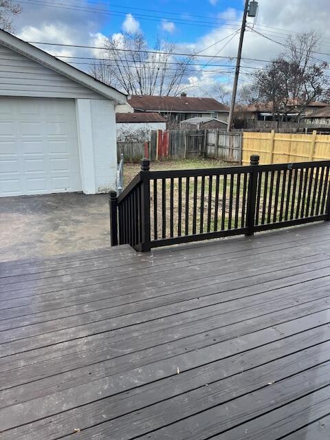 wooden deck featuring a garage and an outdoor structure