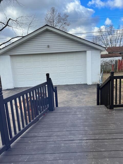 wooden terrace featuring an outbuilding and a garage