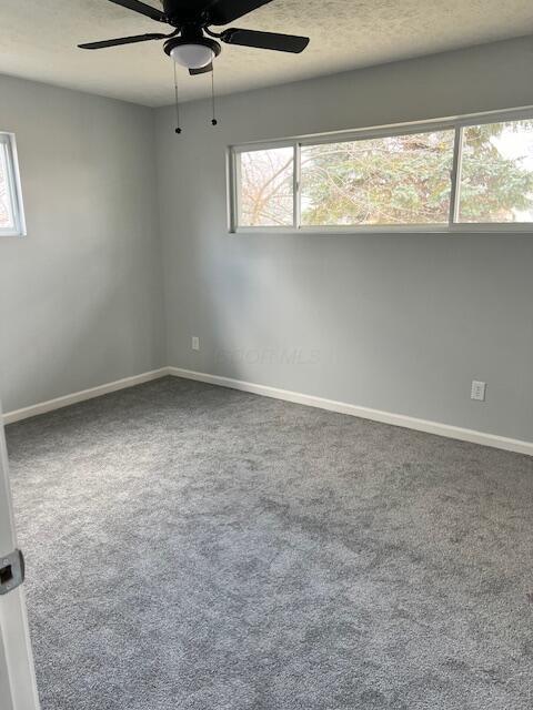 carpeted empty room featuring ceiling fan