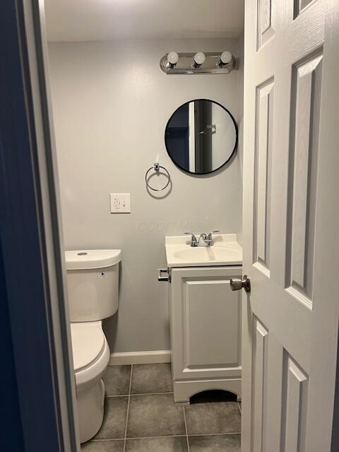 bathroom with tile patterned flooring, vanity, and toilet