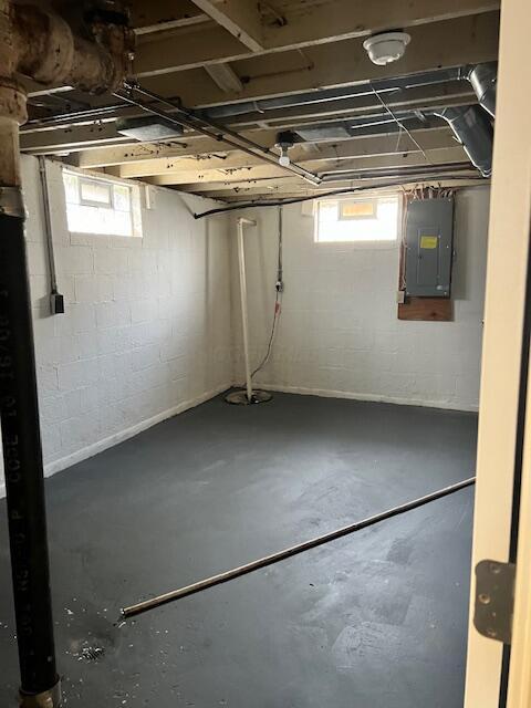 basement featuring electric panel and a wealth of natural light