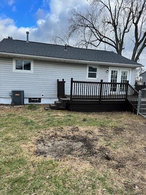 back of property with central AC and a deck