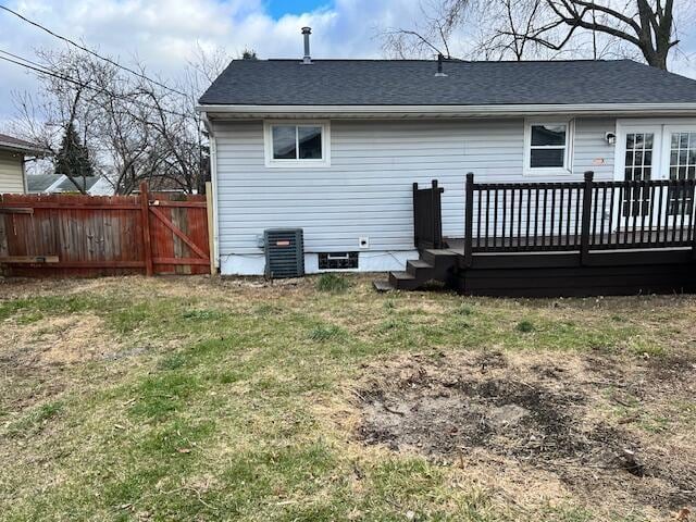 rear view of property featuring a yard, a deck, and central air condition unit