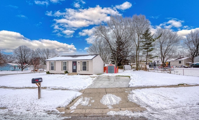 view of front of home with a storage shed, an outdoor structure, and fence