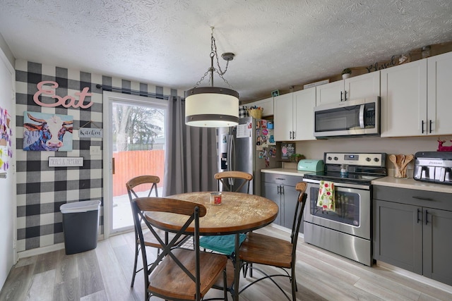 kitchen featuring appliances with stainless steel finishes, light wood-style flooring, gray cabinetry, and light countertops