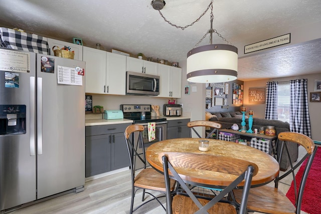 dining area with a textured ceiling and light wood-type flooring