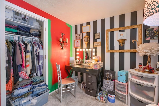 interior space with a closet, carpet floors, a textured ceiling, and wallpapered walls