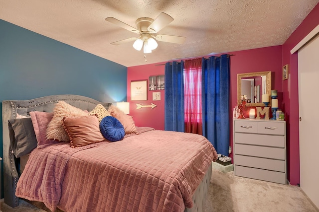 bedroom featuring a ceiling fan, carpet floors, and a textured ceiling