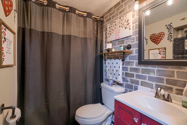 full bath featuring brick wall, toilet, a shower with shower curtain, vanity, and a textured ceiling