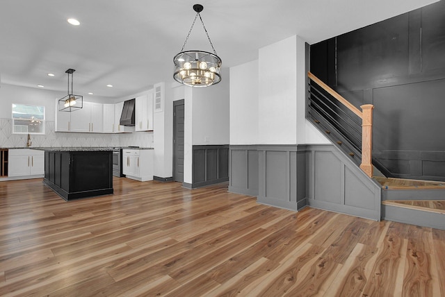 262 N 17th St, Columbus, OH 43203 - kitchen with a large island, premium range hood, white cabinets, decorative light fixtures, and gas range