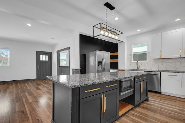 262 N 17th St, Columbus, OH 43203 - kitchen featuring white cabinets, a center island, dark stone countertops, and appliances with stainless steel finishes