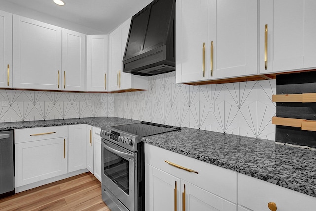 262 N 17th St, Columbus, OH 43203 - kitchen with white cabinets, light hardwood / wood-style flooring, dark stone counters, premium range hood, and appliances with stainless steel finishes
