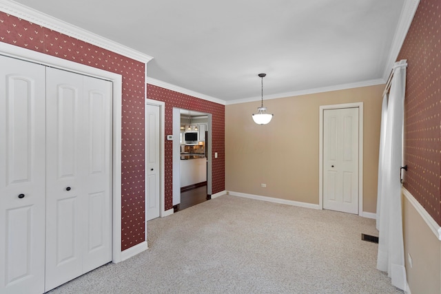 unfurnished dining area with light carpet and crown molding