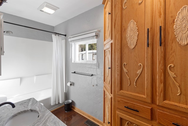 bathroom featuring shower / bath combo, wood-type flooring, and sink