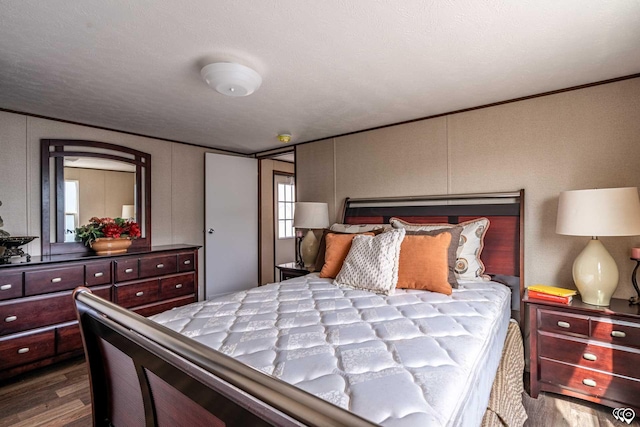 bedroom featuring hardwood / wood-style floors and crown molding