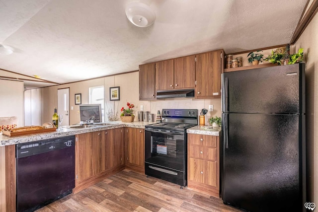 kitchen with sink, crown molding, hardwood / wood-style floors, and black appliances