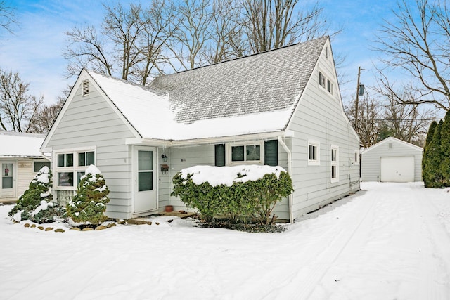 view of front of house with a garage and an outbuilding