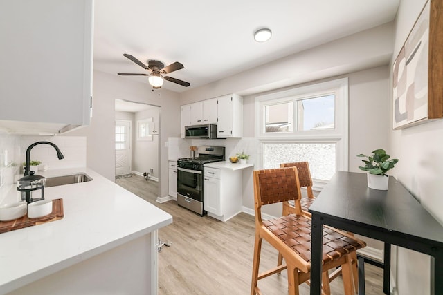 kitchen featuring stainless steel appliances, decorative backsplash, white cabinetry, and sink