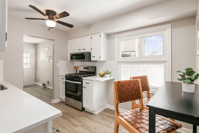 kitchen featuring stainless steel appliances, white cabinets, tasteful backsplash, and light hardwood / wood-style flooring