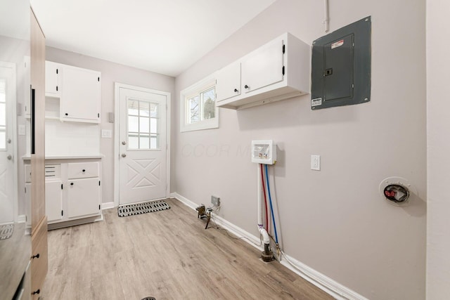 laundry area with light hardwood / wood-style floors and electric panel