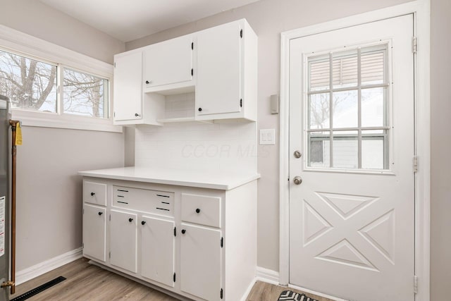 kitchen with white cabinets and light hardwood / wood-style flooring