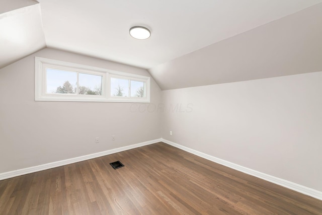 bonus room with vaulted ceiling and dark hardwood / wood-style flooring