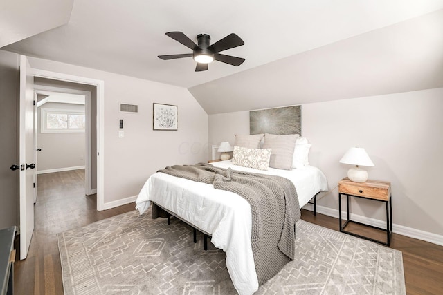 bedroom with ceiling fan, dark wood-type flooring, and lofted ceiling