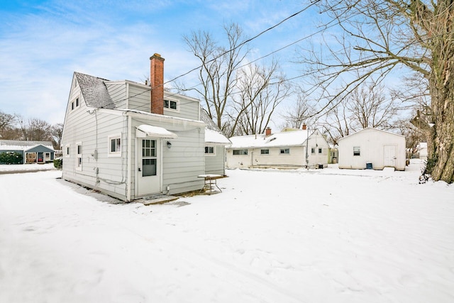 view of snow covered rear of property