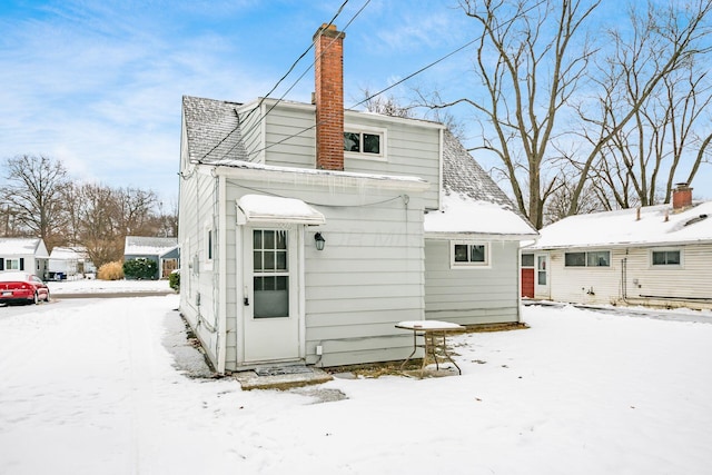 view of snow covered rear of property