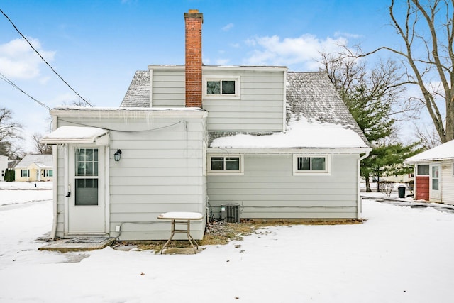 snow covered rear of property with central AC