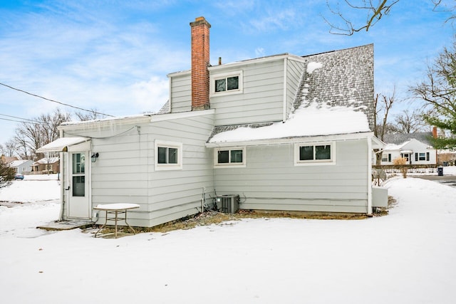 snow covered property with cooling unit