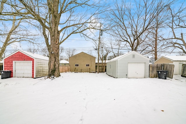 yard covered in snow with a garage and an outdoor structure