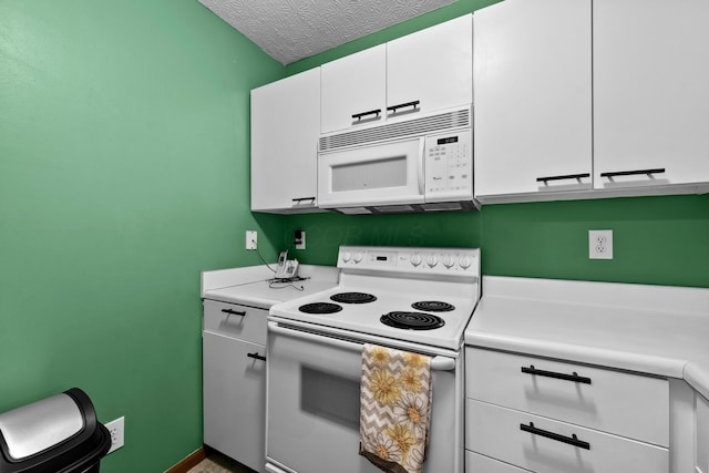 kitchen with white appliances, a textured ceiling, and white cabinetry