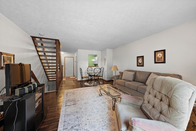 living room featuring a textured ceiling and dark hardwood / wood-style floors