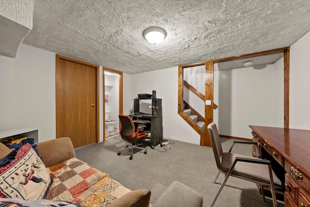 carpeted office featuring a textured ceiling