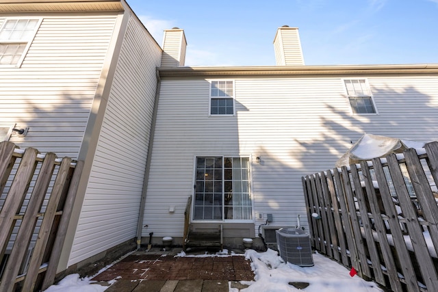 snow covered rear of property with cooling unit