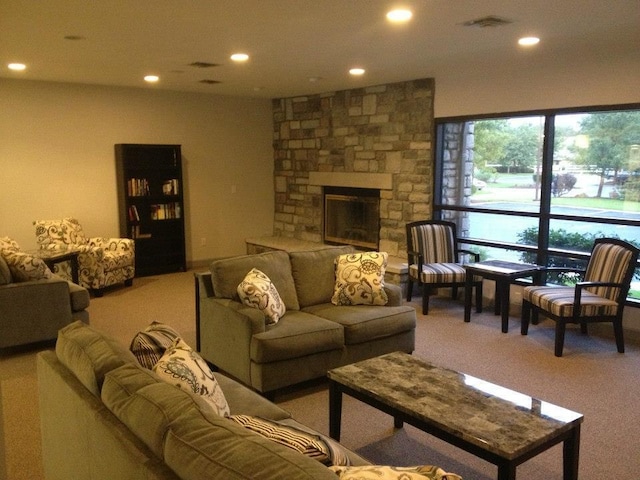 living room with carpet floors and a stone fireplace