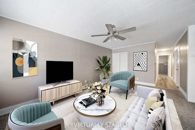 carpeted living room with ceiling fan and ornamental molding