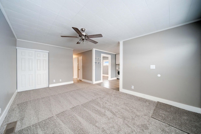 interior space with ceiling fan, ornamental molding, and carpet